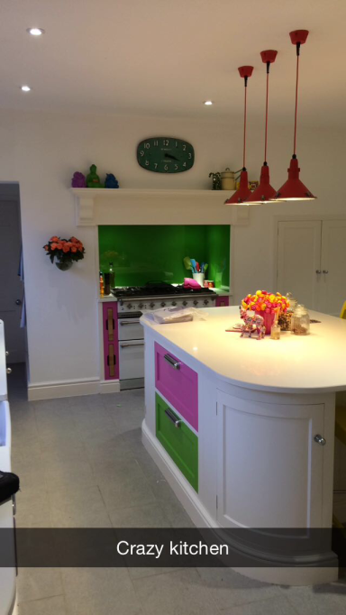 Bright kitchen featuring a colourful design with green and pink accents and modern appliances.