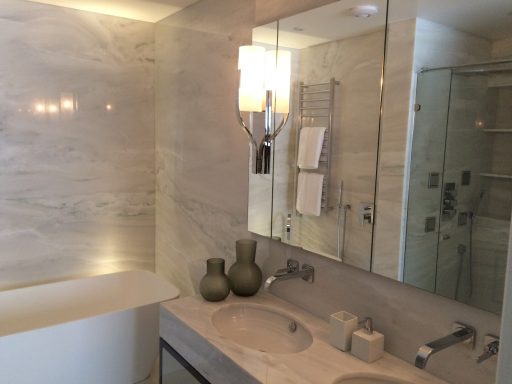 Modern bathroom featuring double sinks, marble walls, and stylish decor.