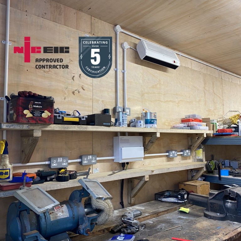 Workshop with trunking and a mounted heater on a wooden wall.