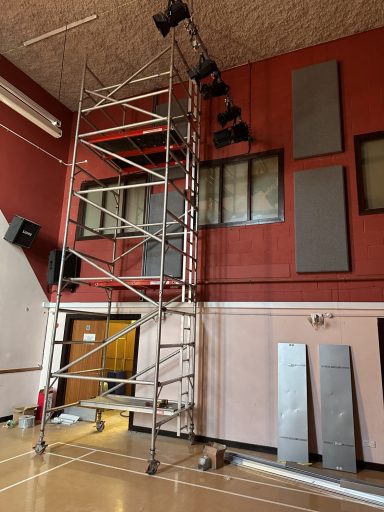A metal scaffolding with stage lights inside a rehearsal space.