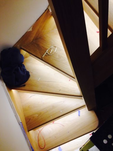 A wooden spiral staircase with some items scattered on the steps.