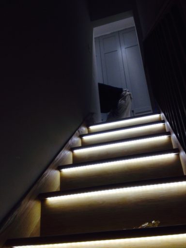 Brightly lit stairs leading to a door, with a figurine at the top of the stairs.